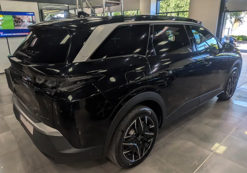 Peugeot 5008 Hybrid 145 GT noir Perla vue en 3/4 arrière droit, avec toit contrasté gris et jantes biton.