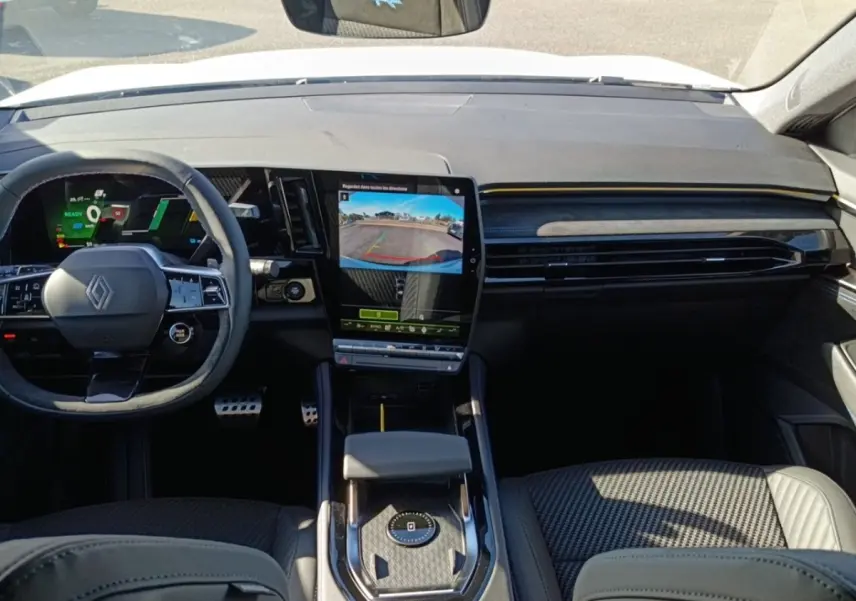 Intérieur de Renault Austral Esprit Alpine, vue avant centrée sur tableau de bord et écran tactile vertical affichant caméra de recul.