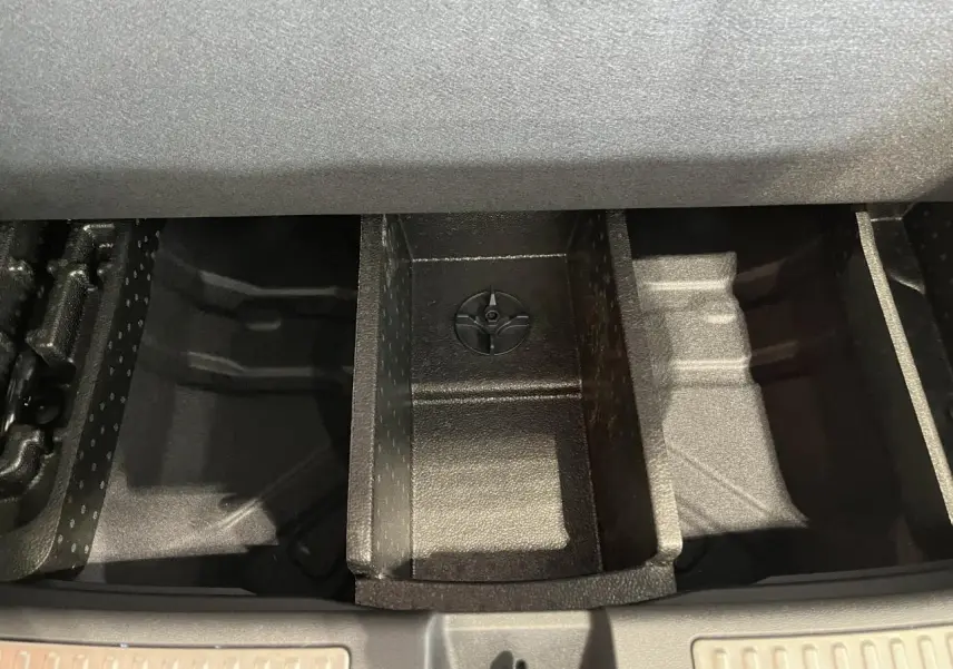 Compartiment de rangement sous le plancher de coffre du Renault Rafale blanc 2025, vue plongeante sur les séparateurs internes.