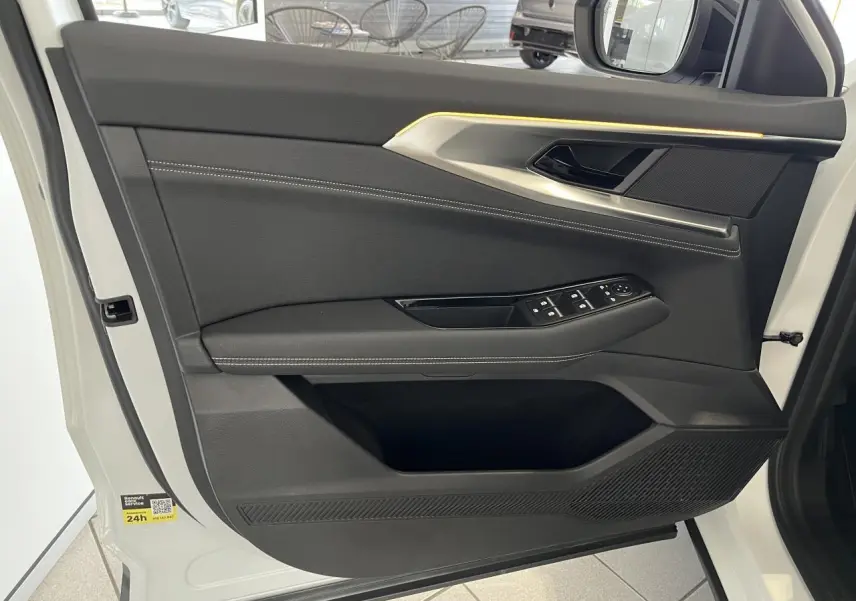Porte avant gauche ouverte d'une Renault Rafale blanche 2025, avec garniture noire et surpiqûres argentées.