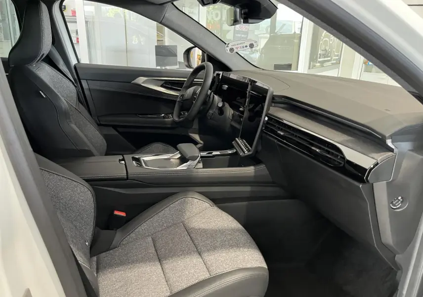 Intérieur de la Renault Rafale 2025 blanc, vue côté conducteur, sièges sport gris textile et tableau de bord moderne.