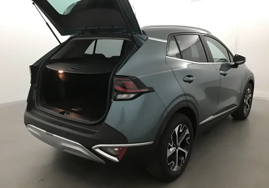 KIA SPORTAGE gris Sirius vu 3/4 arrière droit avec coffre ouvert et feux arrière LED allumés.