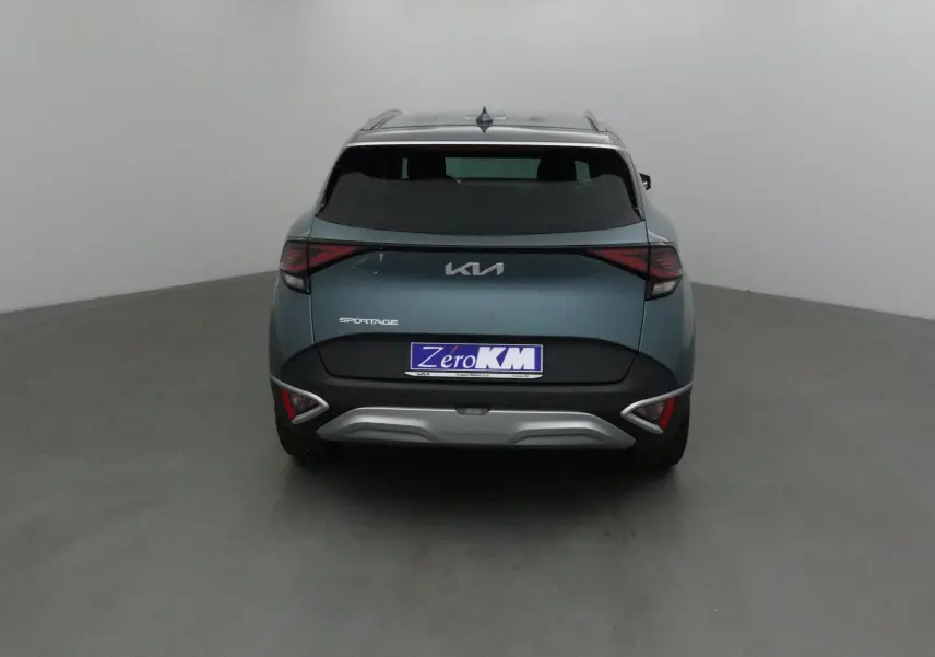 Vue arrière d'un KIA Sportage gris Sirius 2025 avec feux LED et logo KIA moderne visible.