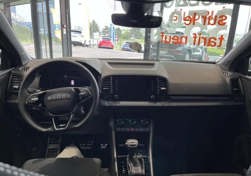 Vue intérieure avant du Skoda Karoq gris 2025, tableau de bord et volant multifonctions avec levier de vitesses DSG7.