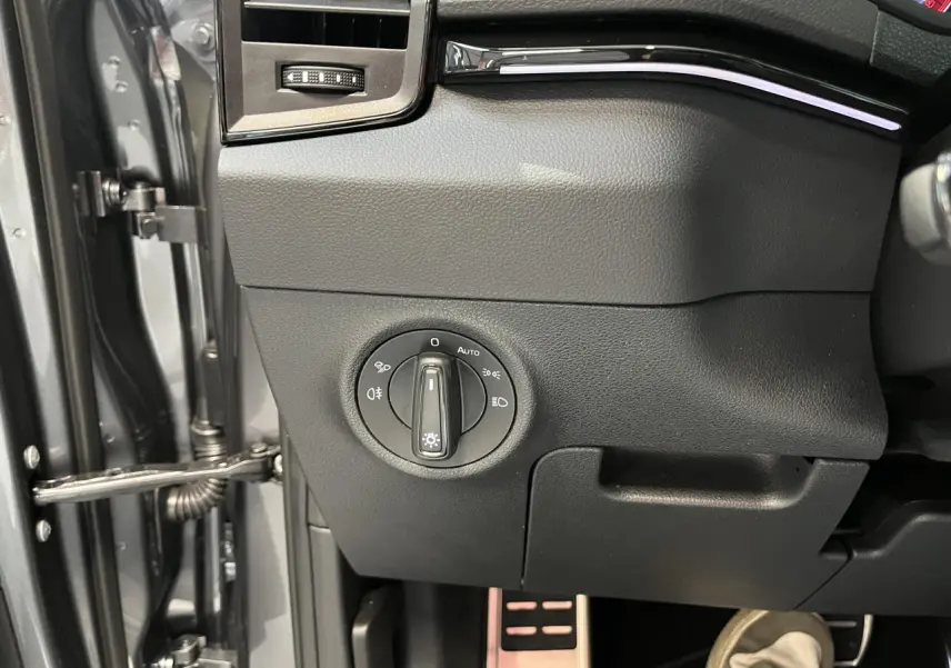 Détail du tableau de bord côté gauche avec commande des phares sur SKODA KAROQ gris 2025 Sportline.