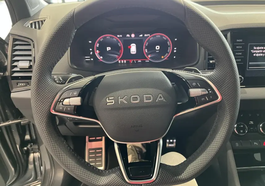 Vue rapprochée du volant perforé noir SKODA KAROQ 2025 avec tableau de bord digital rouge et noir.
