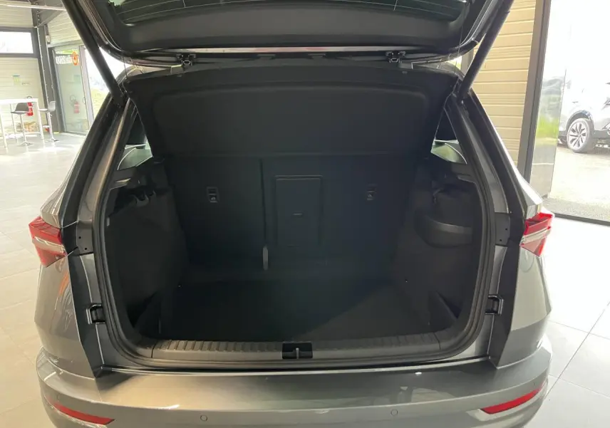 Vue arrière du coffre ouvert d'un SUV SKODA KAROQ gris métallisé 2025 avec hayon électrique et feux LED.