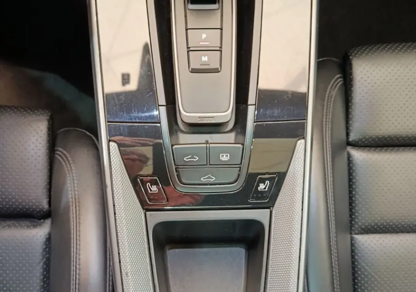 Vue plongeante sur la console centrale noire du Porsche 911 Carrera 4S Coupé 2019 avec levier de vitesse et sièges en cuir perforé.