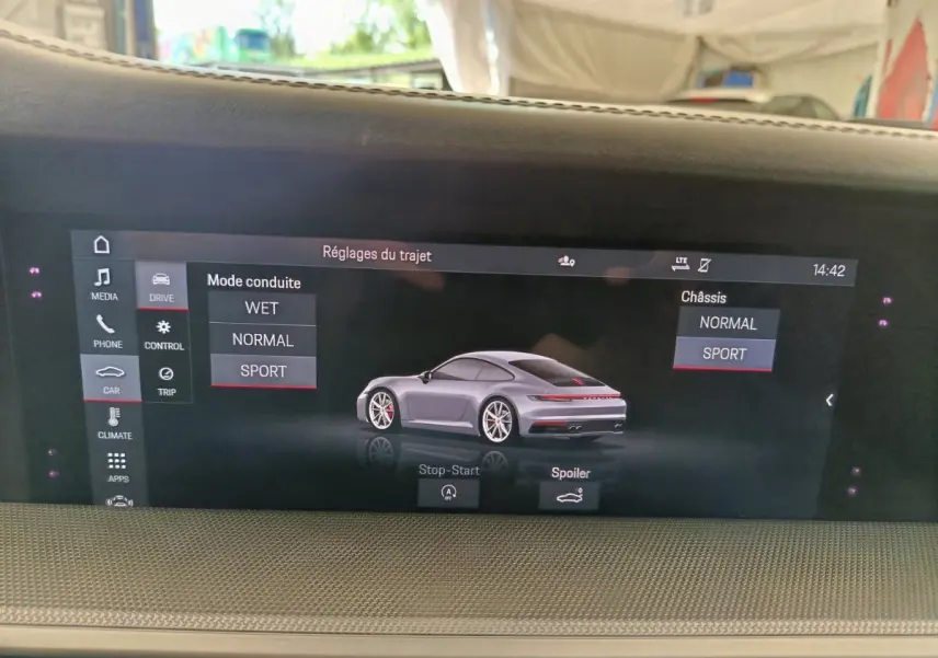 Écran tactile intérieur affichant les réglages de conduite d’une Porsche 911 Carrera 4S Coupé gris foncé en vue 3/4 arrière.