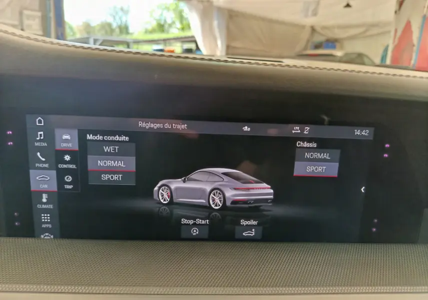 Écran tactile intérieur montrant une Porsche 911 Carrera 4S Coupé gris foncé en vue 3/4 arrière.