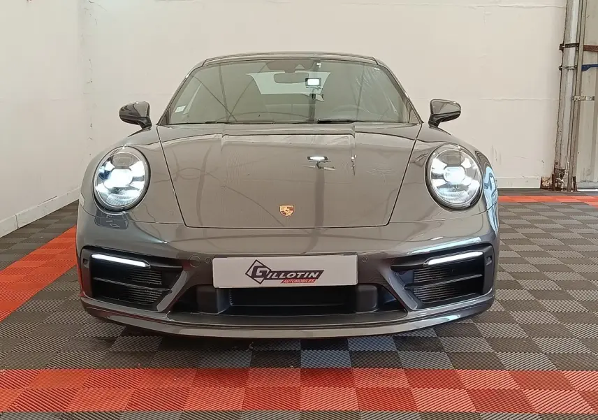 Vue frontale d'une Porsche 911 Carrera 4S Coupé gris foncé avec phares LED allumés en intérieur.