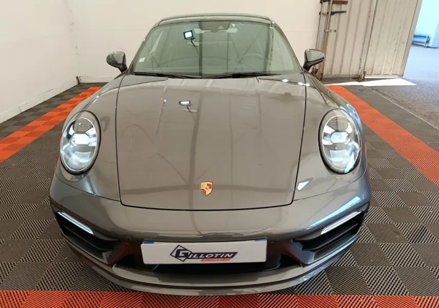 Vue avant d'une Porsche 911 Carrera 4S Coupé 2019 gris foncé avec phares LED et logo Porsche visible sur le capot.
