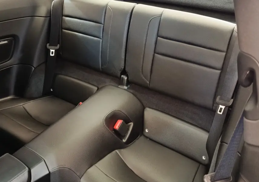 Vue rapprochée des sièges arrière en cuir noir de la Porsche 911 Carrera 4S Coupé 2019, avec ceinture de sécurité visible.