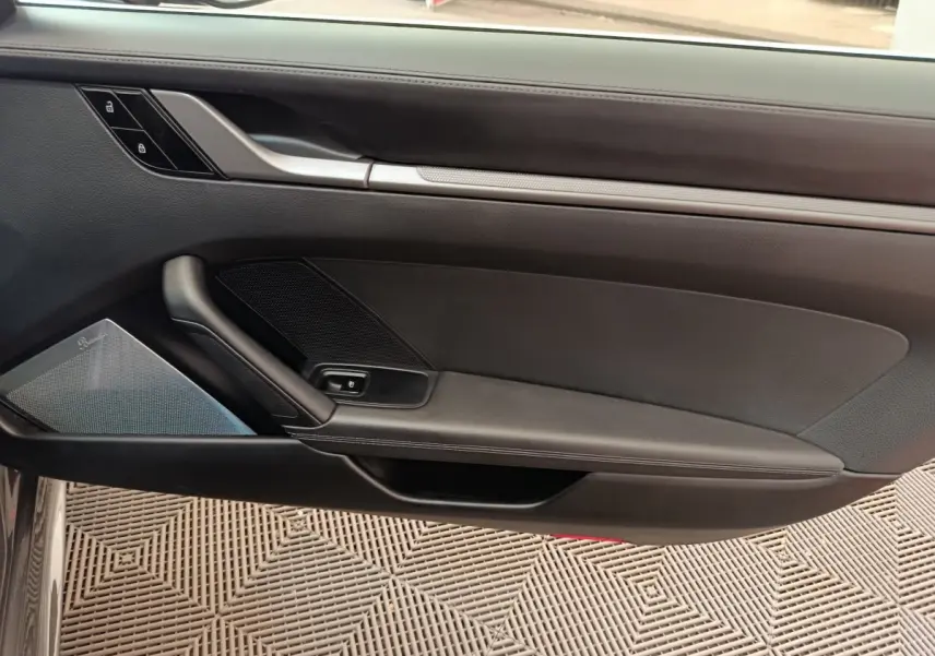 Vue intérieure du panneau de porte côté conducteur de la Porsche 911 Carrera 4S Coupé gris foncé avec haut-parleur intégré.