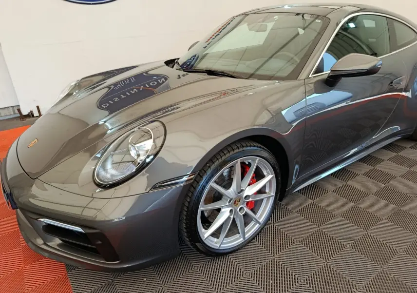 Vue 3/4 avant droite d'une Porsche 911 Carrera 4S Coupé gris foncé avec jantes alliage et étriers rouges.
