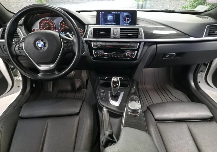 Vue intérieure avant de la BMW Série 4 430i Gran Coupé 2019, avec tableau de bord noir et console centrale élégante.