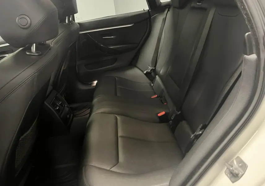 Vue intérieure côté droit des sièges arrière en cuir noir d'une BMW Série 4 Gran Coupé blanc.