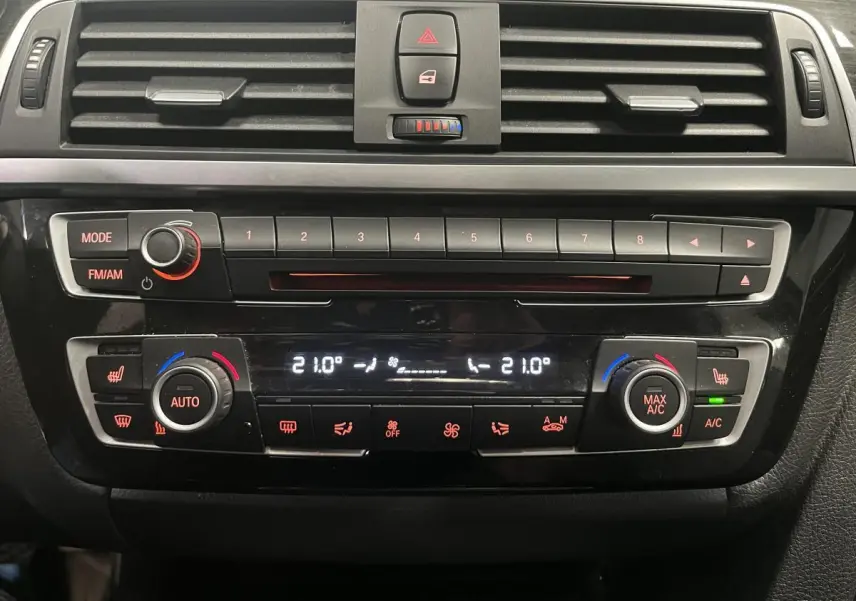 Vue rapprochée de la console centrale noire de la BMW Série 4 430i avec commandes climatisation et radio.