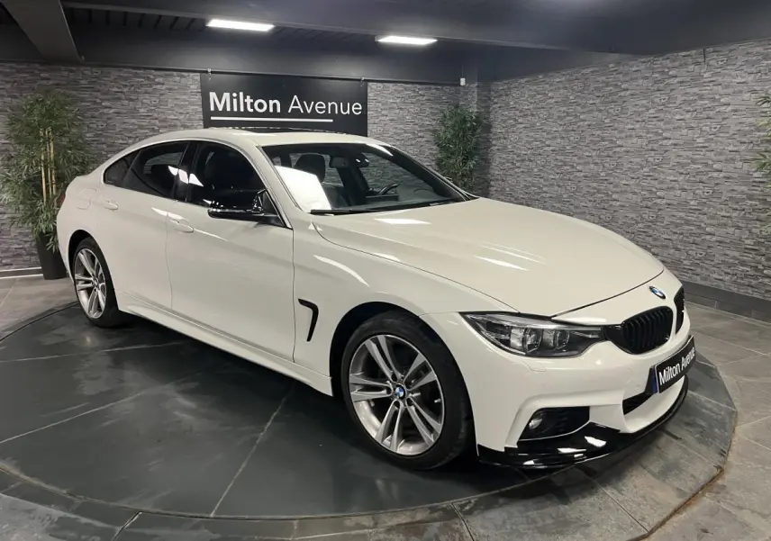BMW Série 4 Gran Coupé blanc vue 3/4 avant droit, avec jantes alliage 18'' et calandre noire chromée.