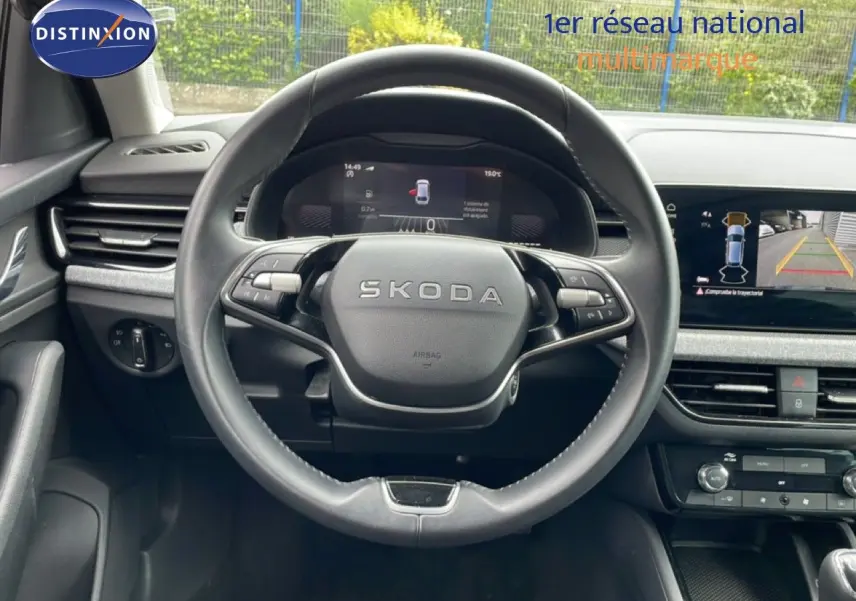 Vue intérieure centrée sur le volant noir de la Skoda Scala 2025 avec tableau de bord numérique et écran multimédia.