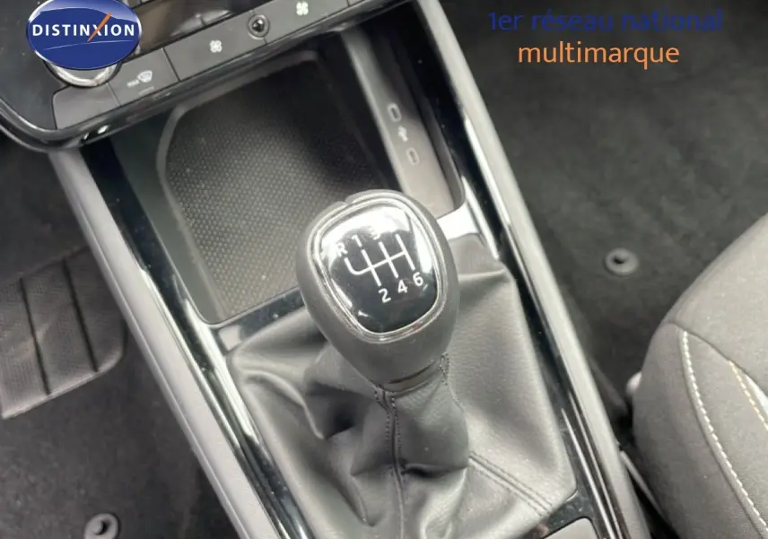 Vue rapprochée sur le levier de vitesses manuel noir de la Skoda Scala 1.0 TSI 115CH, intérieur tissu gris.