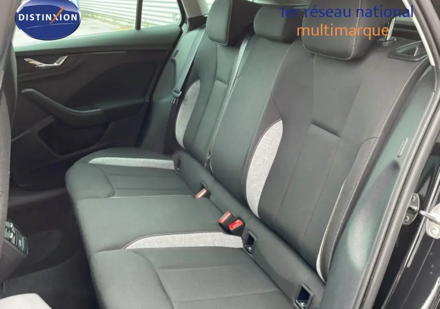 Vue intérieure côté arrière droit montrant les sièges arrière en tissu gris et noir d'une Skoda Scala 2025 noir magique métal.