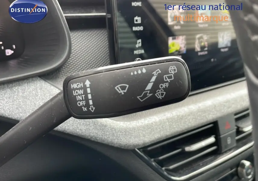 Gros plan sur la commande d’essuie-glace dans l’habitacle gris noir du Skoda Scala noir magique métal, côté conducteur.