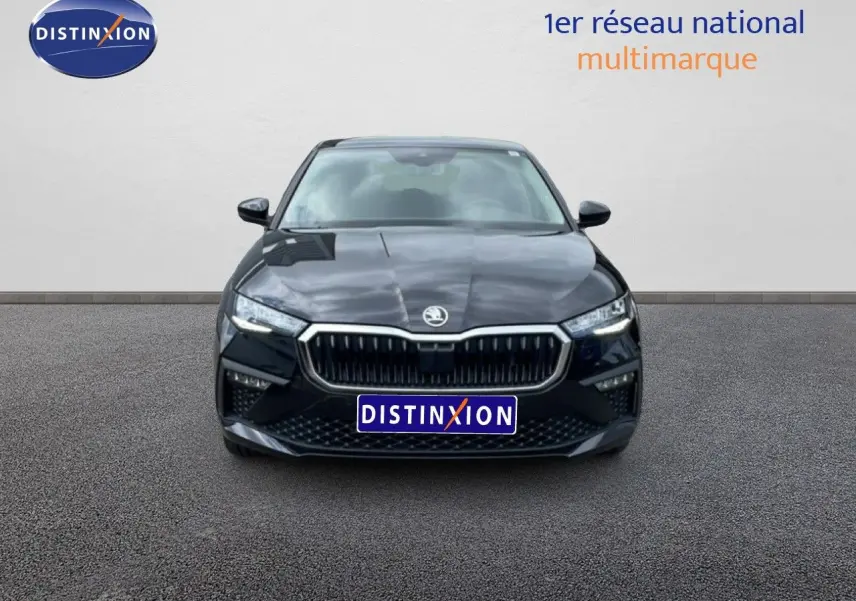 Vue frontale d'une Skoda Scala noire métallisée avec calandre chromée et phares LED allumés.