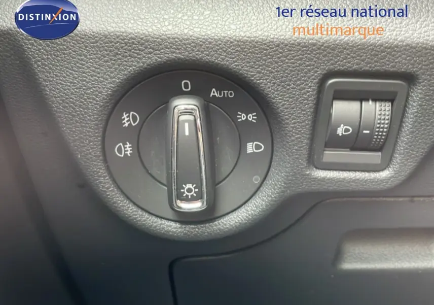 Gros plan sur la molette de réglage des phares et le variateur d'intensité lumineuse dans l'habitacle d'une Skoda Scala noire.