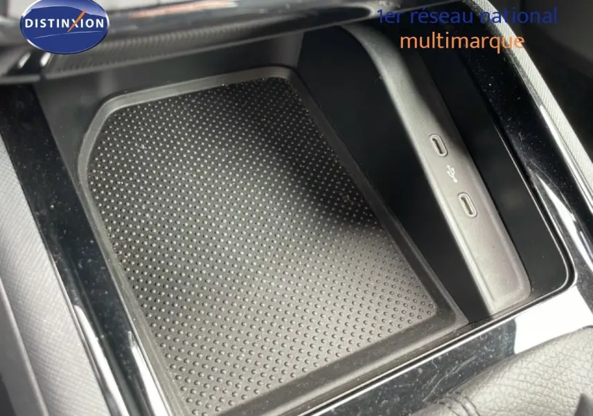 Gros plan sur la console centrale noire d’une Skoda Scala 2025 avec zone de recharge et ports USB visibles.