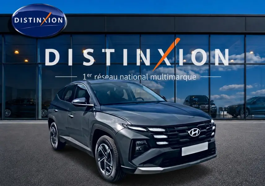 Hyundai Tucson gris ecotronique en 3/4 avant droit, avec calandre noire et jantes alliage 17 pouces visibles.