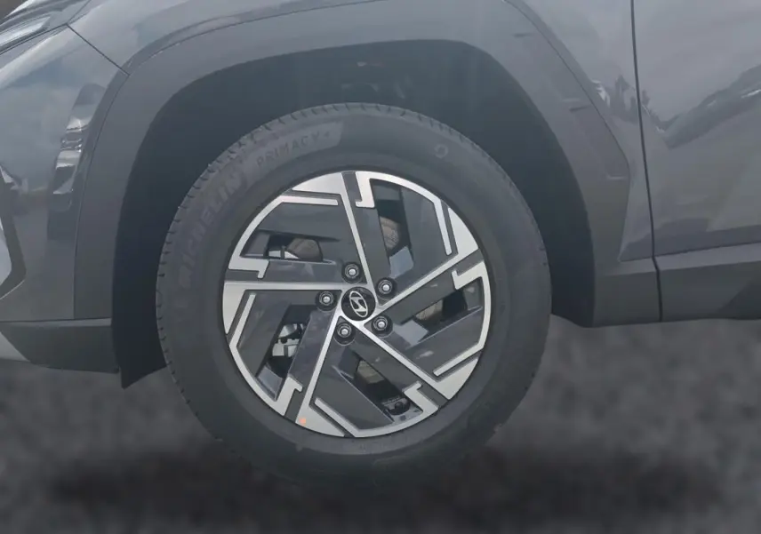 Gros plan sur la roue avant gauche du Hyundai Tucson gris écotronique avec jante alliage 17 pouces au design moderne.