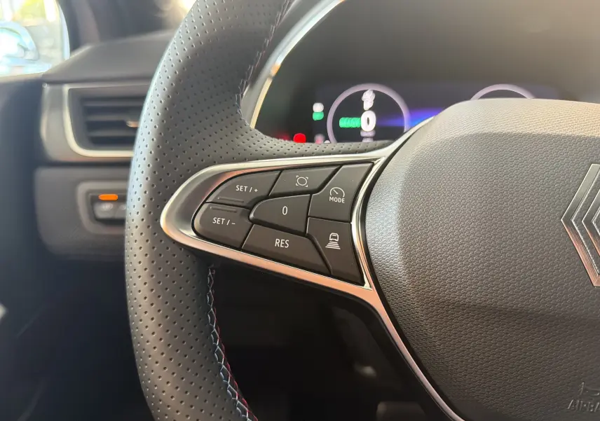 Gros plan sur le volant perforé avec commandes intégrées du Renault Captur E-Tech 160 Esprit Alpine, intérieur noir.