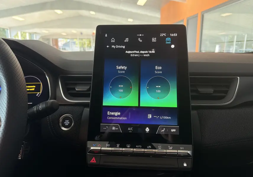 Vue intérieure centrée sur l'écran tactile vertical du tableau de bord du Renault Captur E-Tech gris Rafale, avec démarrage sans clé.