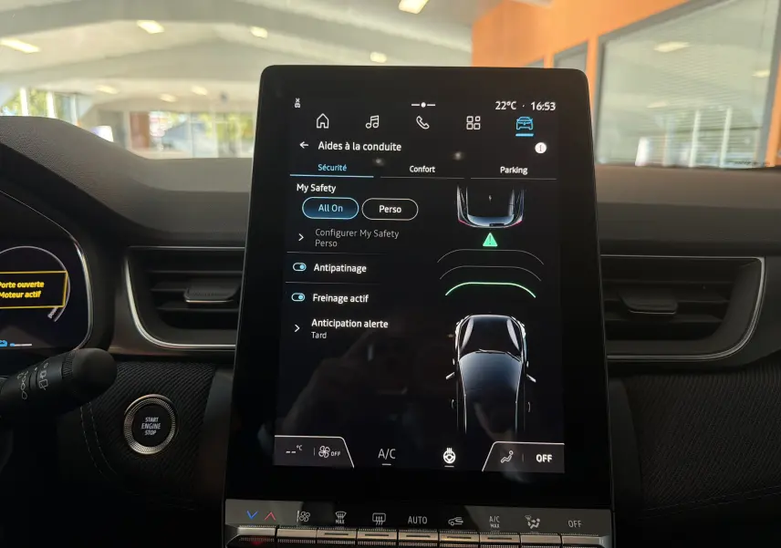 Vue intérieure centrée sur l'écran tactile du tableau de bord du Renault Captur E-Tech 160 Esprit Alpine, ambiance sombre.