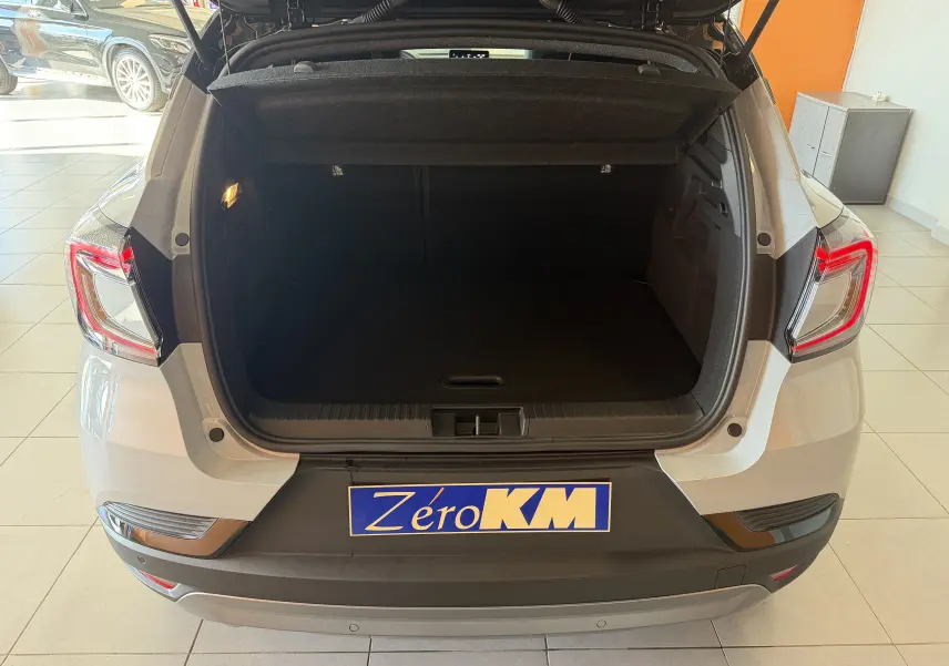 Coffre ouvert vu de l'arrière d'un Renault Captur E-Tech 160 Esprit Alpine gris Rafale en showroom.