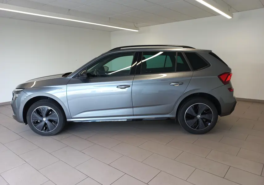 Vue de profil côté gauche d’un Skoda Kamiq 2024 gris graphite avec jantes spécifiques Monte Carlo et toit noir.