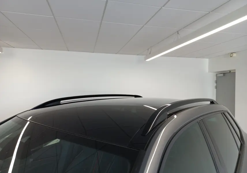 Toit panoramique et barres de toit noires sur le côté droit d’un Skoda Kamiq Monte Carlo gris graphite 2024.