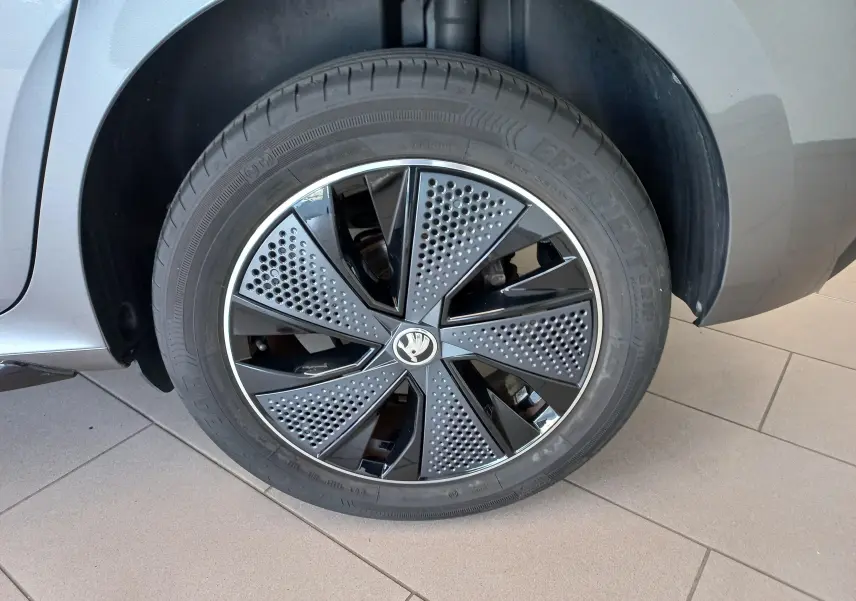 Gros plan sur la roue avant droite du Skoda Kamiq 2024 gris graphite, mettant en valeur la jante Monte Carlo au design perforé noir et gris.