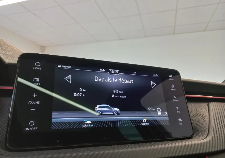 Écran tactile central du Skoda Kamiq 2024 en gros plan, affichant l'interface de conduite avec vue latérale du véhicule gris graphite.
