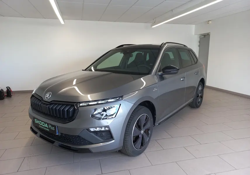 Vue 3/4 avant droite du Skoda Kamiq Monte Carlo 2024 gris graphite avec calandre noire et jantes spécifiques.