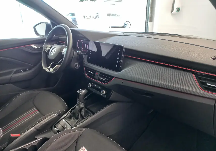 Vue intérieure côté conducteur du Skoda Kamiq 2024 Monte Carlo, avec tableau de bord noir et touches rouges décoratives.