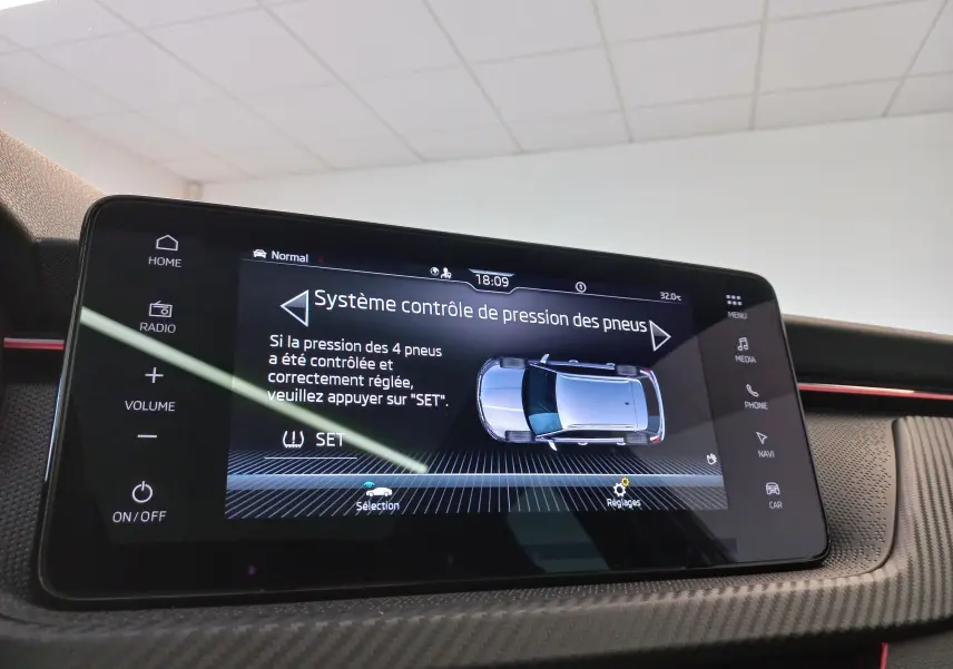 Écran tactile central du Skoda Kamiq 2024 Monte Carlo montrant le contrôle de pression des pneus, intérieur noir et rouge.