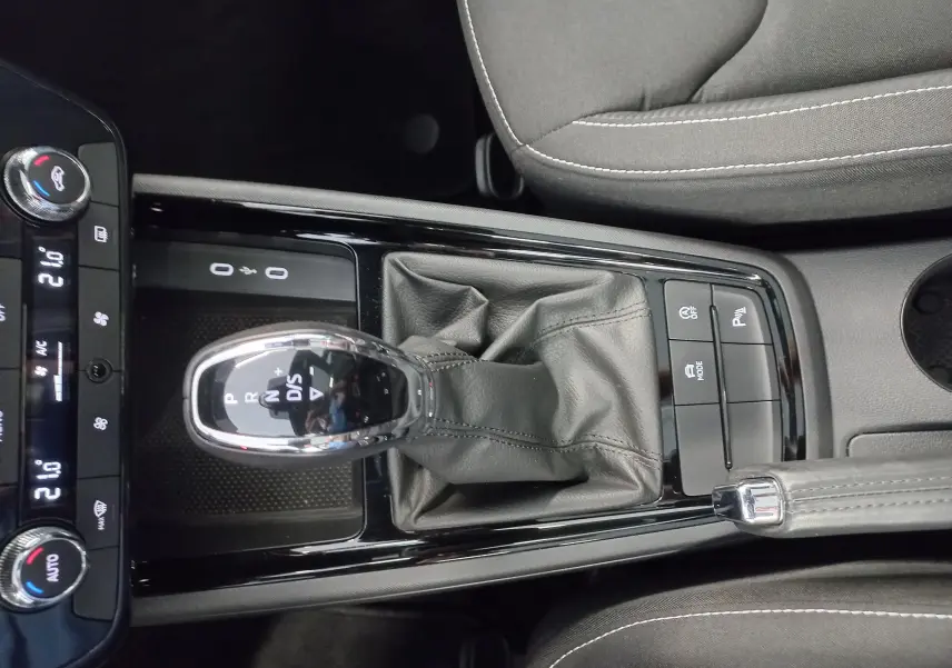 Vue rapprochée de la console centrale du Skoda Kamiq 2024 Monte Carlo, avec levier de vitesse automatique et boutons de contrôle.