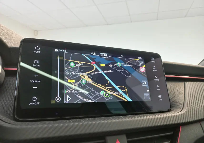 Écran tactile central du Skoda Kamiq 2024 Monte Carlo en gros plan, affichant la navigation GPS sur fond noir.