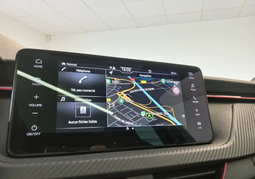 Écran tactile central du Skoda Kamiq Monte Carlo 2024, affichant la navigation et les options multimédias, avec finition carbone.