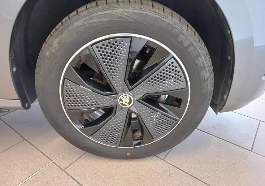 Gros plan sur la roue avant droite du Skoda Kamiq 2024 gris graphite, mettant en valeur la jante Monte Carlo au design perforé noir et gris.