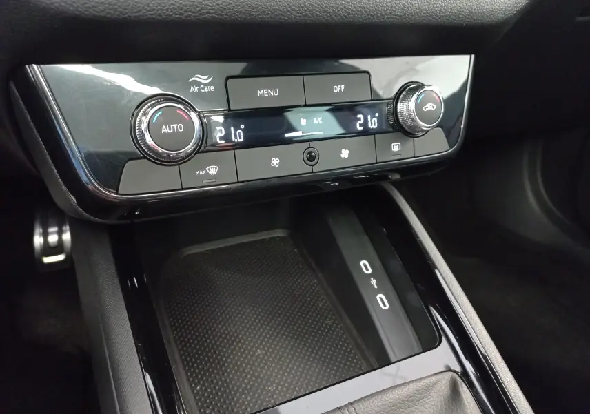 Détail de la console centrale du Skoda Kamiq 2024 Monte Carlo, avec commandes climatisation et zone de recharge sans fil.
