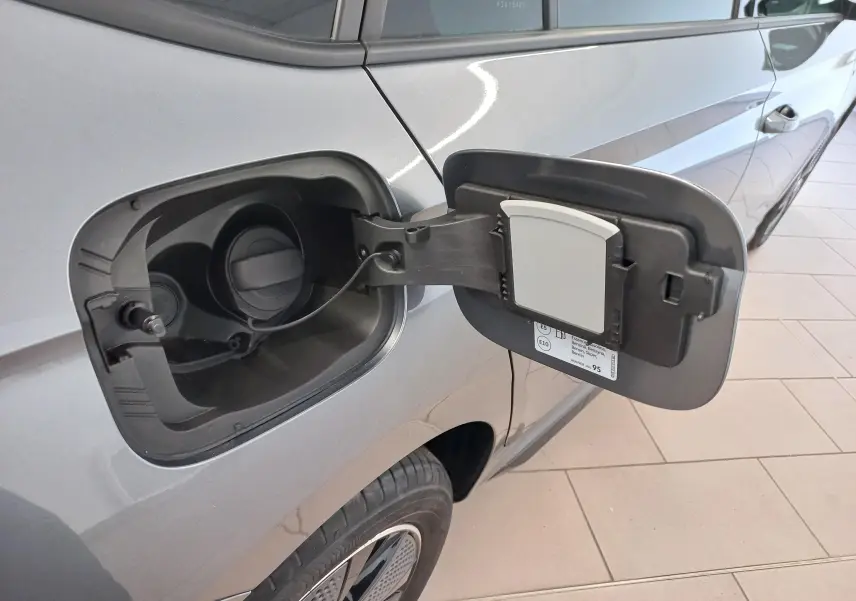 Détail de la trappe à carburant ouverte côté gauche d’un Skoda Kamiq gris graphite 2024, vue latérale.