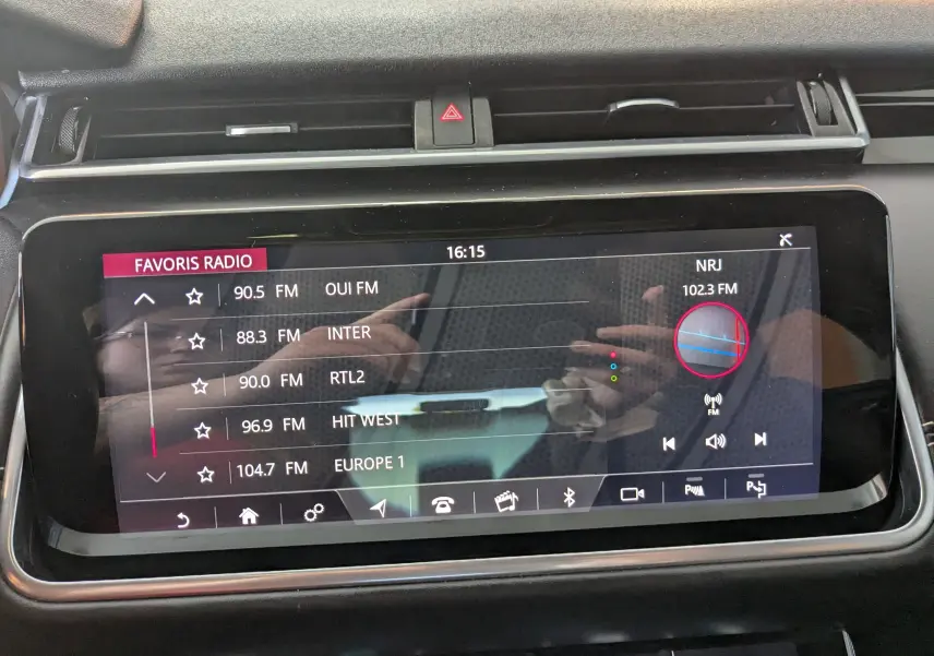 Écran tactile central du Range Rover Velar noir 2020 affichant la liste des radios FM favorites avec interface moderne.